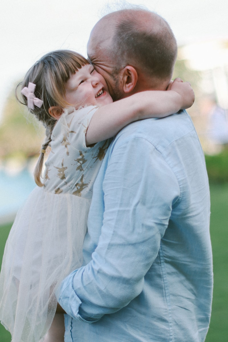 Pere serrant sa fille dans ses bras en riant