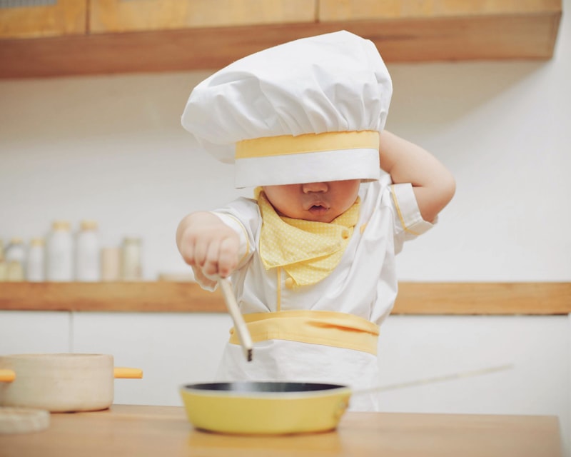 Enfant avec une toque de chef en cuisine